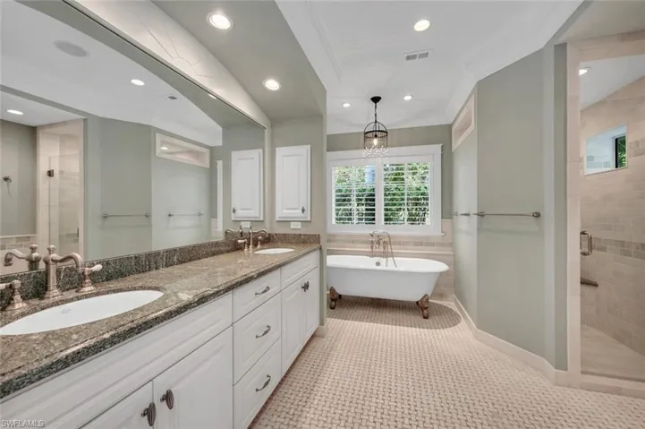 Bathroom with crown molding, shower with separate bathtub, tile patterned floors, and vanity
