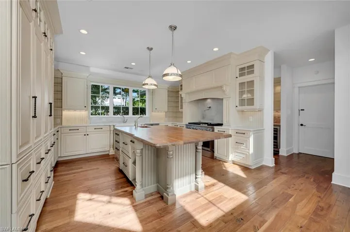 Kitchen with a kitchen island with sink, a breakfast bar, stainless steel range, and backsplash