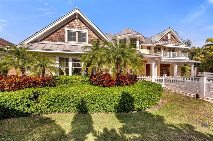 View of front of home with a balcony and a front yard