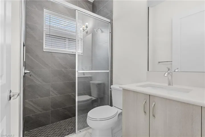 Bath features light cabinetry and natural lighting
