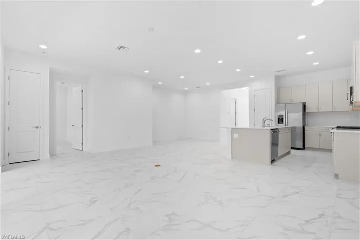 An open-concept great room boasting elegant tile flooring and high ceilings