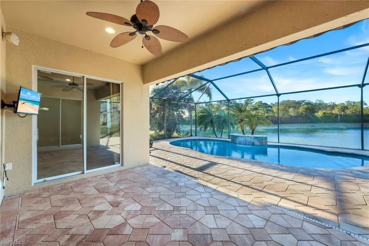View of swimming pool with , ceiling fan, a water view, and a patio