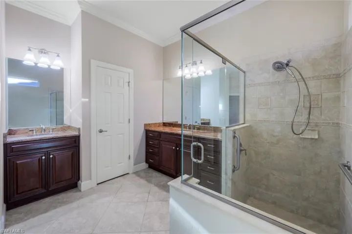 Bathroom with tile patterned flooring, vanity, and ornamental molding