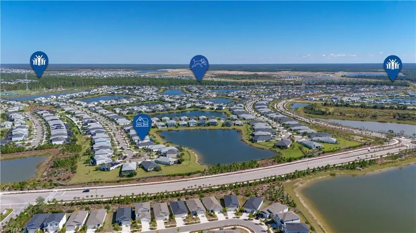 Aerial perspective of a developed residential community featuring numerous single-story homes with dark roofs