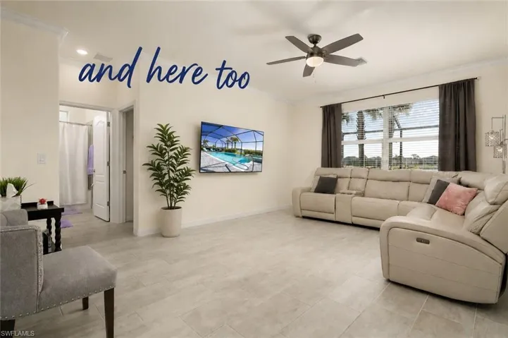 Spacious living area featuring light-toned tile flooring, recessed ceiling lights, and a ceiling fan