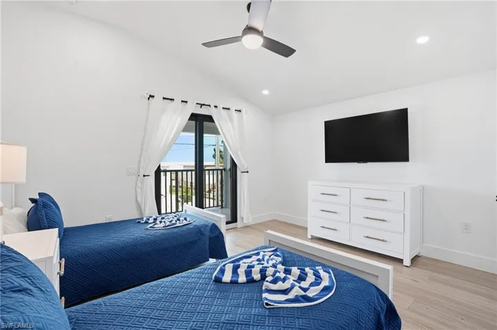 Bedroom with vaulted ceiling, light wood-style flooring, access to outside, ceiling fan, and recessed lighting virtually edited