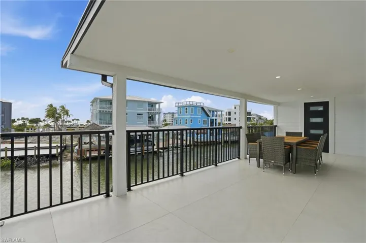 Balcony featuring outdoor dining area, a water view, and a residential view virtually edited