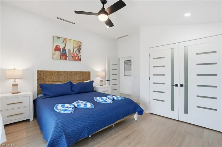 Bedroom featuring light wood-style floors, ceiling fan, a closet, and lofted ceiling virtually edited