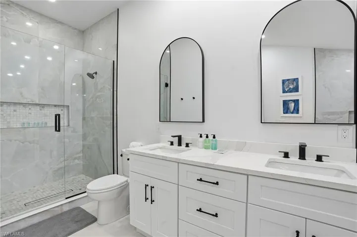 Full bathroom featuring a stall shower, double vanity, and recessed lighting virtually edited