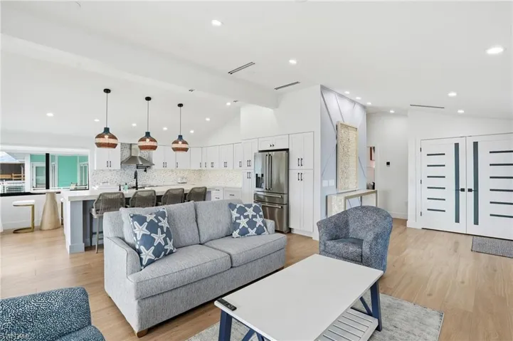 Living area with light wood-type flooring and recessed lighting Virtually Edited