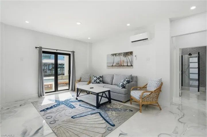 Living room featuring recessed lighting, a wall unit AC, and Epoxy floors Virtually Edited