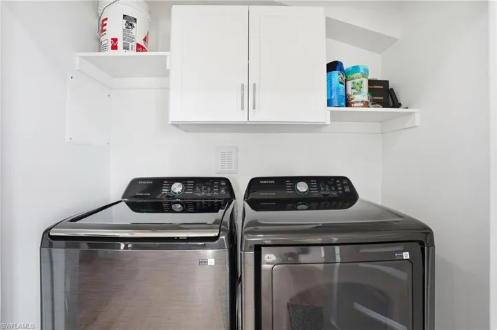 Laundry room with cabinet space and washing machine and clothes dryer virtually edited