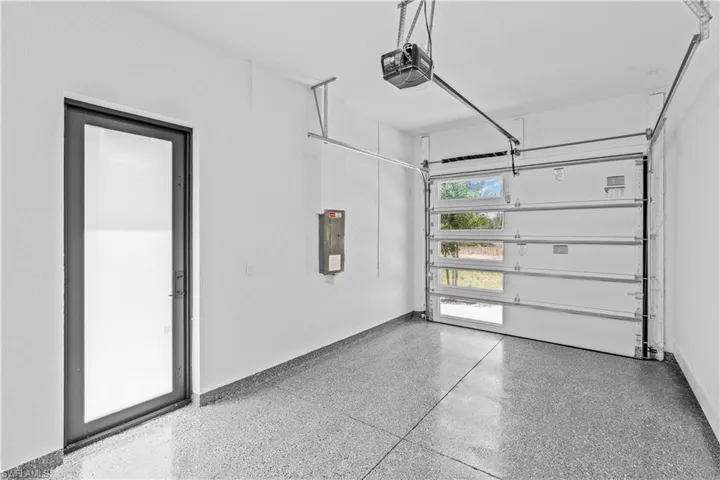 Garage featuring a garage door opener and electric panel