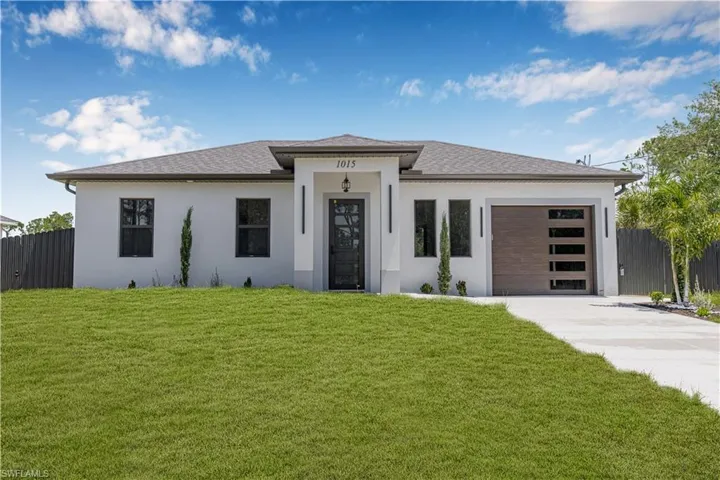 Prairie-style home with driveway, a garage, and stucco siding