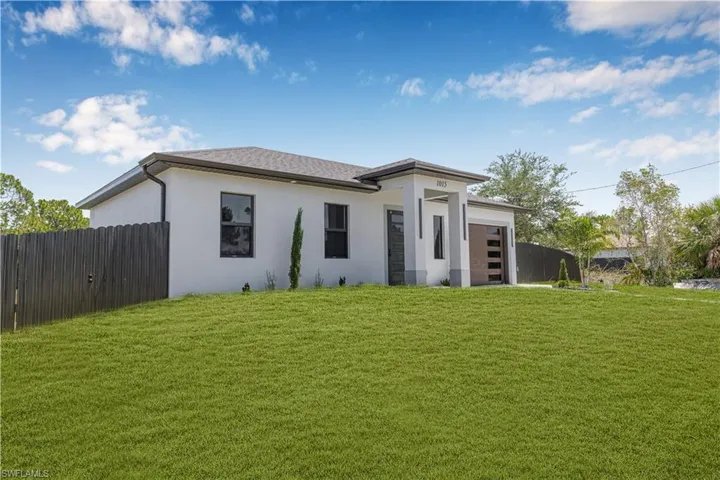 View of front of property featuring an attached garage and stucco siding