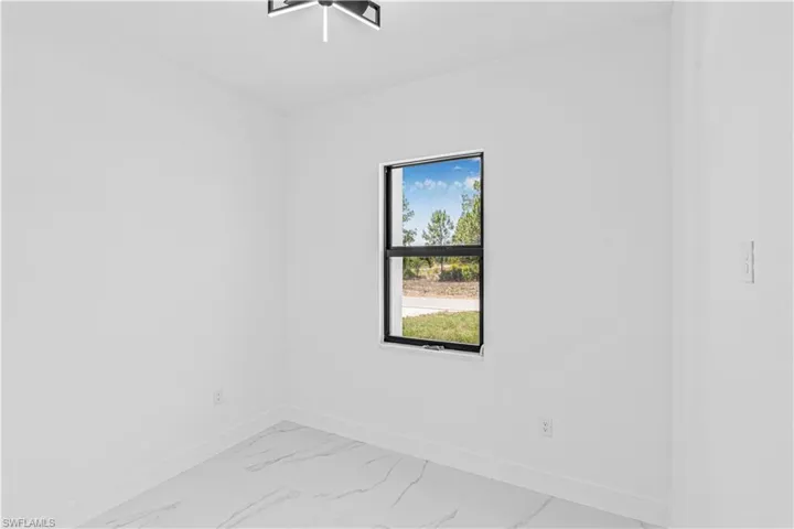 Spare room with baseboards and light marble finish floors