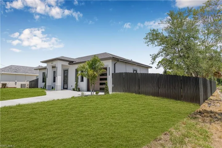 View of front facade with stucco siding, an attached garage, and driveway