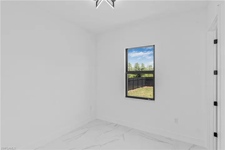 Spare room with baseboards and light marble finish floors