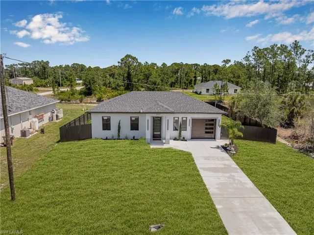 View of front of house with driveway, an attached garage, roof with shingles, and stucco siding