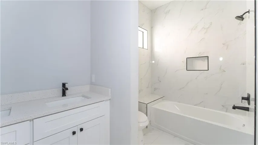 Full bathroom featuring vanity, toilet, and tiled shower / bath