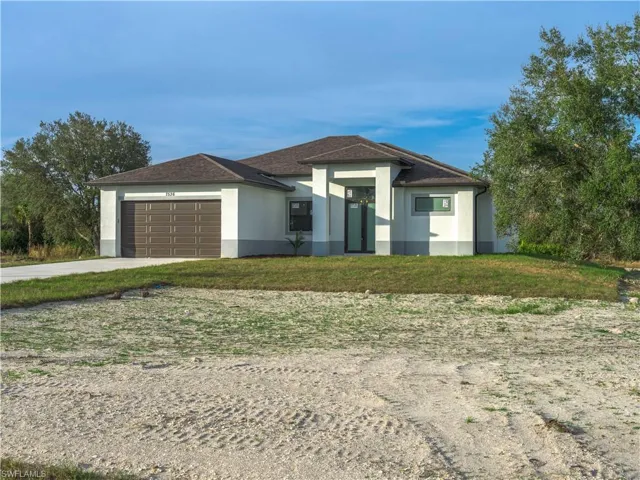 View of front facade with a garage and a front lawn