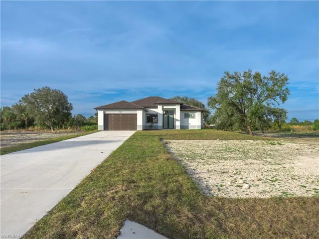 View of front of property featuring a garage and a front yard