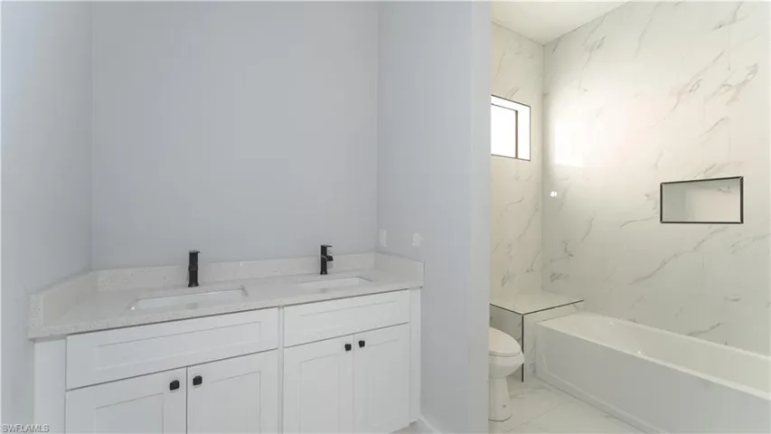 Bathroom with vanity, a bathtub, and toilet