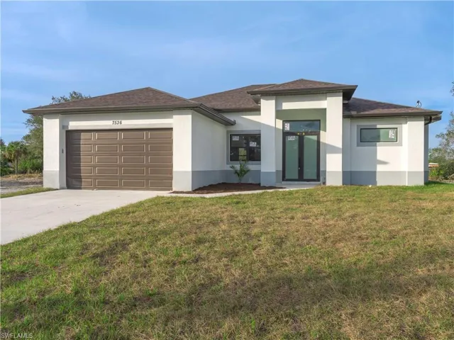 Prairie-style home with a garage and a front lawn