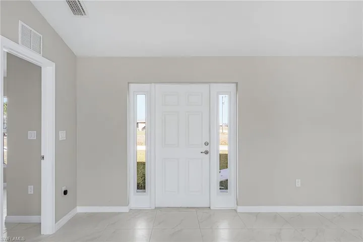 Foyer entrance featuring light marble finish flooring and plenty of natural light