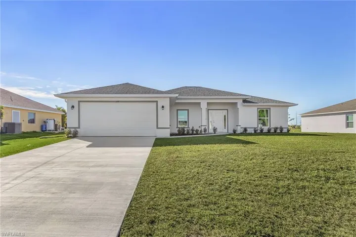 Prairie-style home featuring stucco siding, driveway, and a front lawn