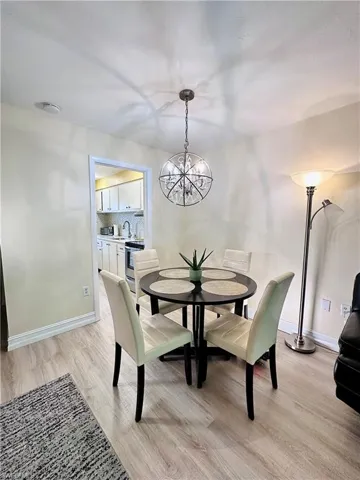 Dining room with light wood finished floors and a chandelier