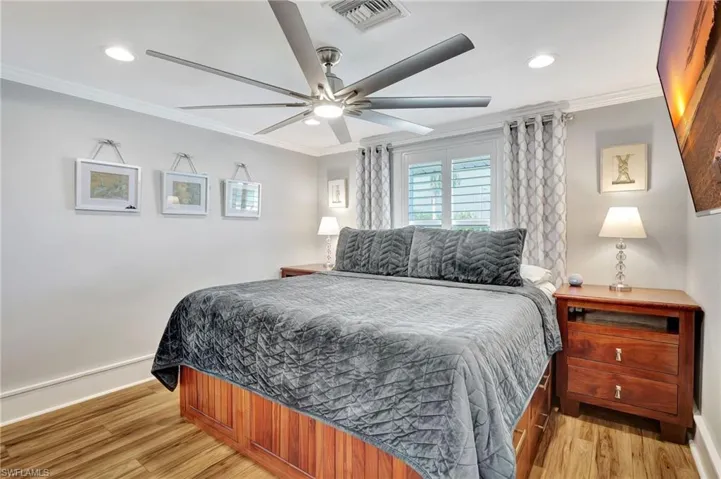 Bedroom with ceiling fan, crown molding, window, plantation shutters, closet