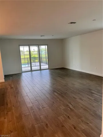 Unfurnished room with dark wood-type flooring