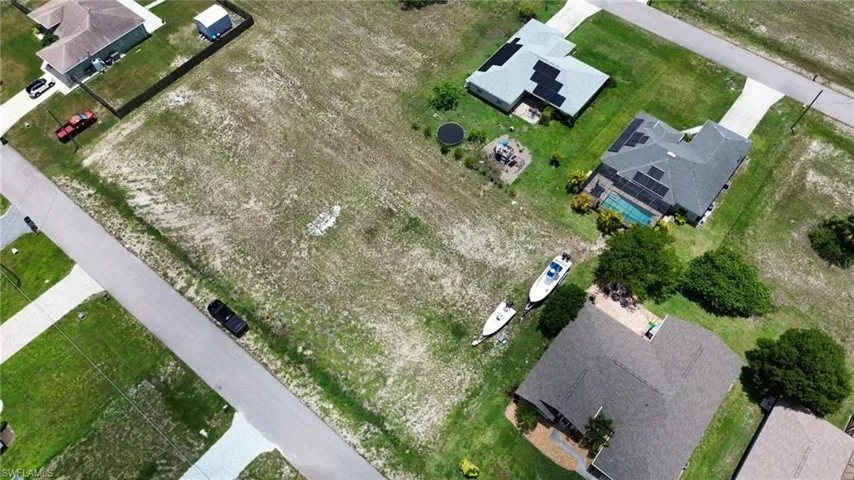 Expansive vacant land parcel featuring clear groundcover and paved street frontage