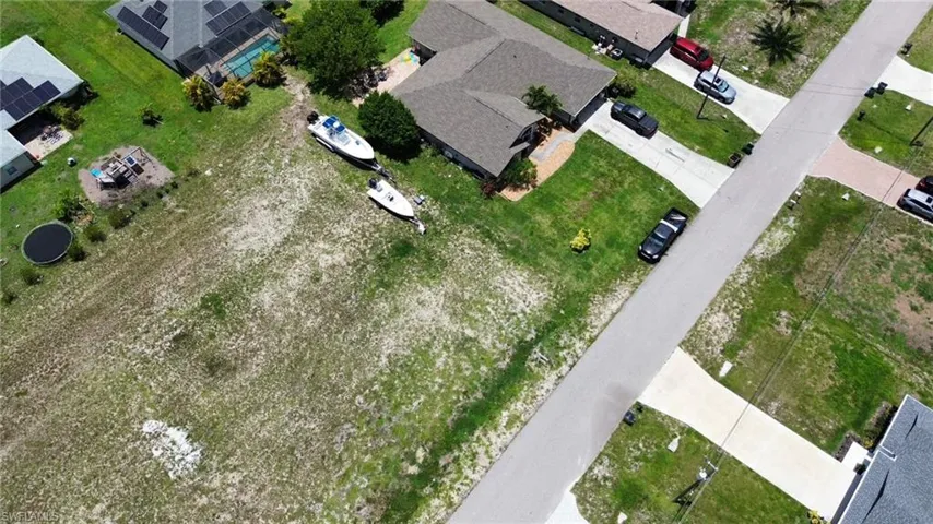 Spacious residential lot featuring a street-facing orientation, partially cleared land, and established surrounding properties