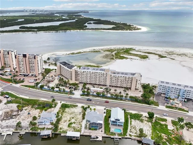 Birds eye view of property with a water view and a view of the beach