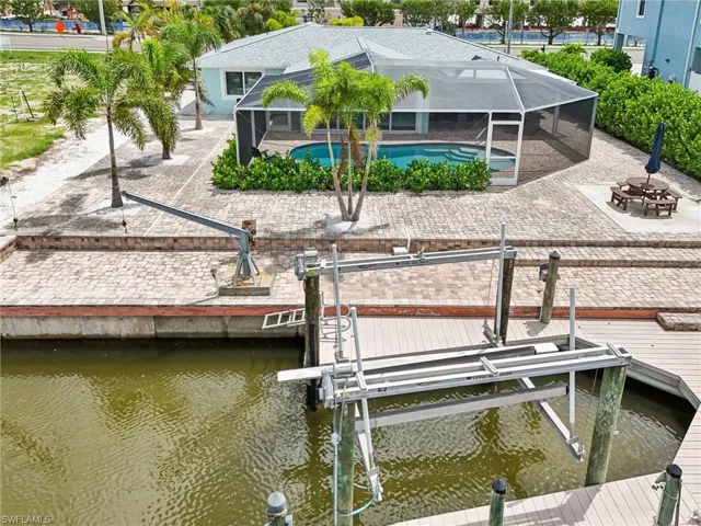 View of dock featuring a water view, a lanai, and a patio area