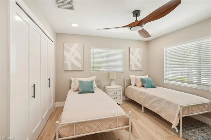 Bedroom featuring light hardwood / wood-style flooring, ceiling fan, and a closet