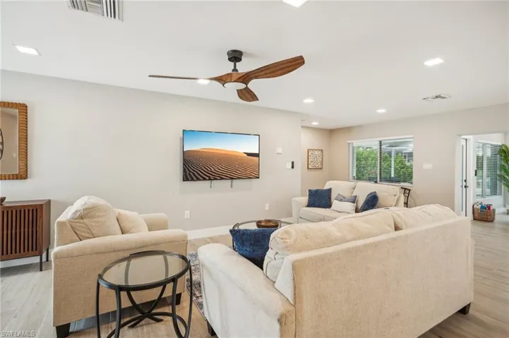 Living room with light wood-type flooring and ceiling fan