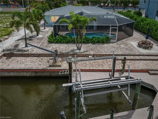 Dock area with a water view, a lanai, a patio area, and a fire pit