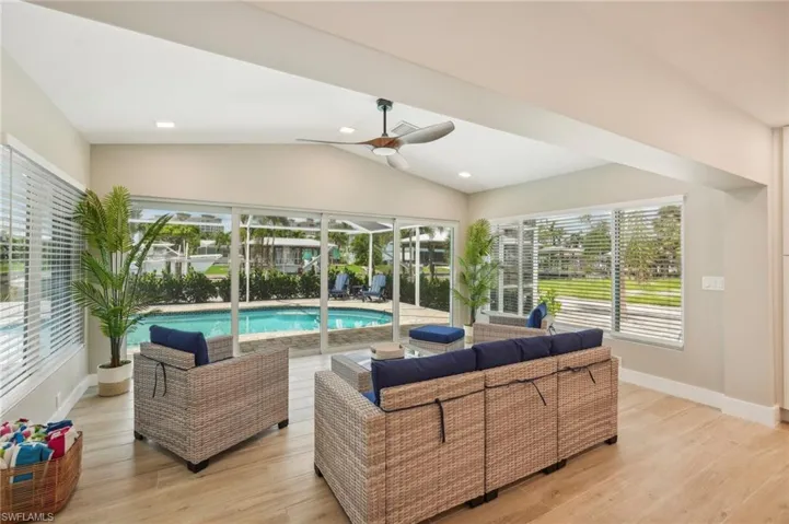 Living room featuring ceiling fan, plenty of natural light, vaulted ceiling, and light hardwood / wood-style flooring