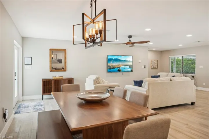 Dining room featuring ceiling fan with notable chandelier and light hardwood / wood-style flooring