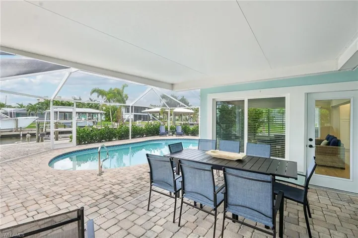 View of pool featuring a patio and glass enclosure