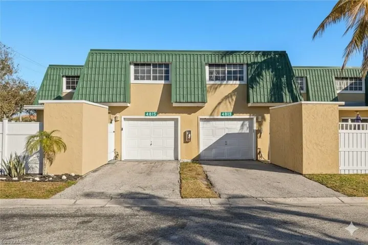View of front of property featuring stucco siding, asphalt driveway, and an attached garage