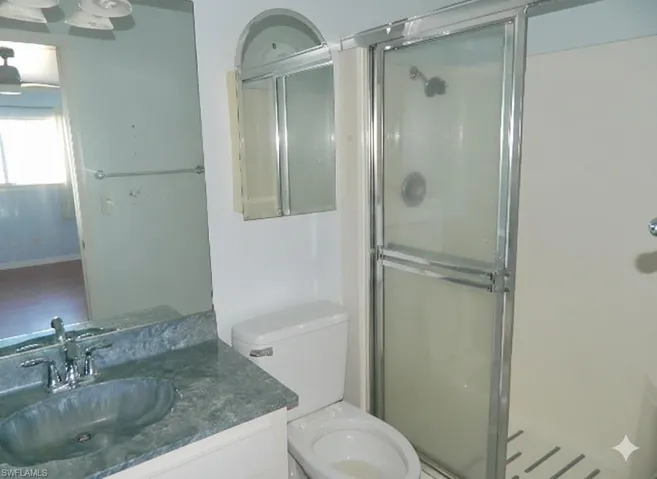 Bathroom featuring a shower stall and vanity