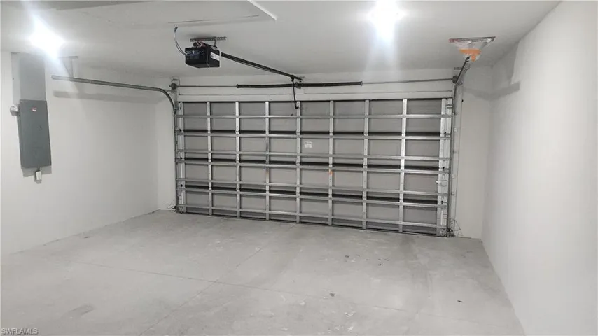 Garage featuring electric panel and a garage door opener