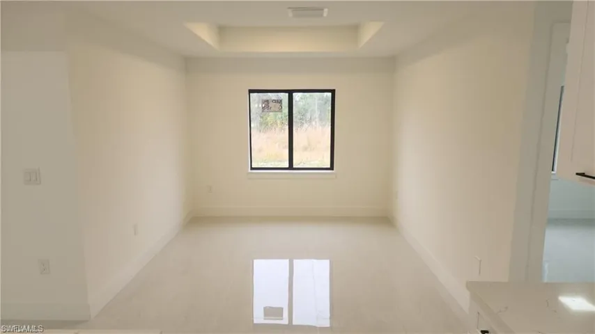 Unfurnished dining area with a raised ceiling