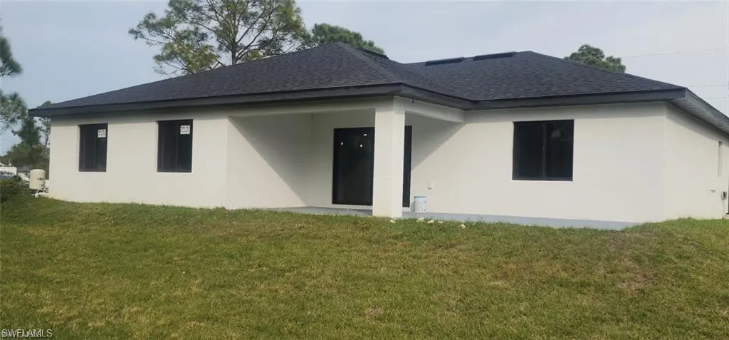 Back of house with a yard