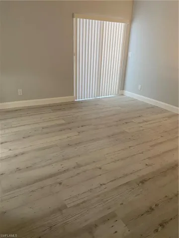 Unfurnished room featuring wood finished floors and baseboards
