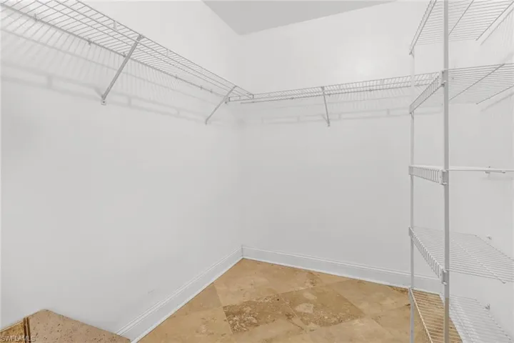 Spacious closet featuring light tile flooring